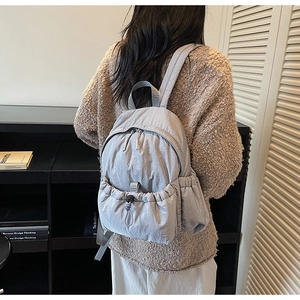 Close-up of lightweight grey canvas backpack with drawstring pocket and nylon texture