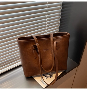 Detailed macro shot of the textured brown tote bag featuring elegant fashion bag engraving