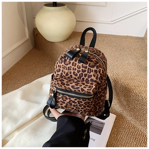 Detailed macro view of trendy leopard print mini backpack with sleek black zipper pulls
