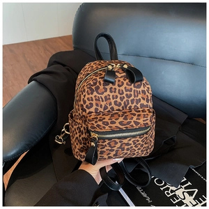 Detail of leopard print backpack featuring premium gold hardware and zipper pockets