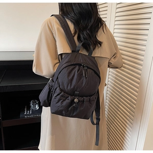 Close-up of black waterproof nylon backpack with drawstring pleated design for women