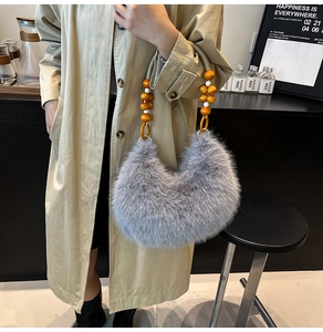 Détail du sac à main en fausse fourrure grise avec poignée en perles de bois sur un manteau