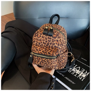 Detailed view of the leopard print mini backpack with golden zippers and leather handles