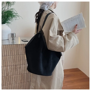 Detail of a large black vintage canvas tote bag shown in a cozy indoor lifestyle setting