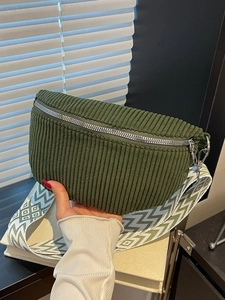 Dark green corduroy crossbody saddle bag with a geometric wide woven shoulder strap