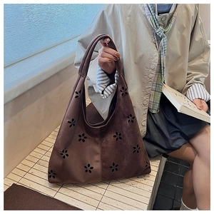 Detailed view of the dark brown suede tote bag with intricate laser-cut floral patterns