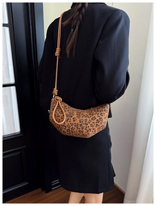 Detail of leopard print crescent bag showing the unique knot design on the shoulder strap