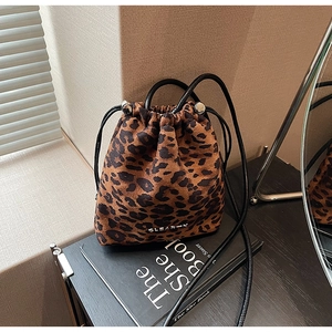 Gros plan du sac seau léopard montrant la texture en daim et le logo métallique CLEAR-K