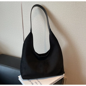 Close-up of black suede hobo bag with crescent silhouette and matte texture