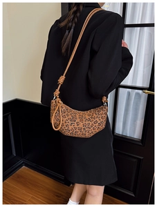 Detail of leopard print crescent bag showing the stylish knotted shoulder strap feature