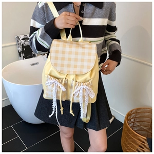 Detail of yellow checkered backpack with lace bows and drawstring pockets