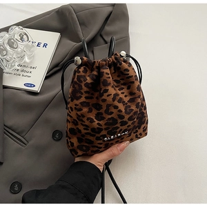 Détail du sac seau imprimé léopard avec cordon de serrage et plaque logo argentée