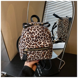 Close-up of leopard print backpack with a black bow detail reflected in a mirror