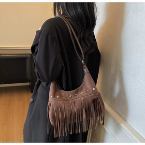 Dettaglio borsa in camoscio marrone con frange e decorazioni a stella in metallo vintage