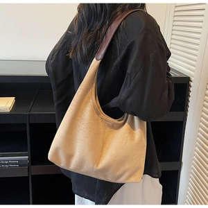 Side view of a khaki suede hobo bag worn by a model showing the slouchy shape and size