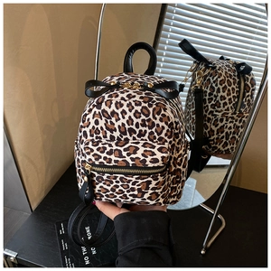 Close-up of leopard print mini backpack with black bow detail and golden metal zipper
