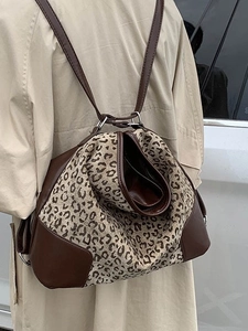 Leopard print canvas backpack with brown leather trim shown on model for daily commute