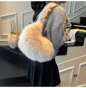 Détail du sac croissant en fausse fourrure beige avec une bandoulière en perles de bois orange