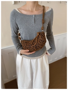 Leopard print crescent bag featuring a brown knotted shoulder strap on a female model