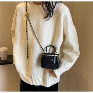 Detail of tweed crossbody box bag with gold metal chain and adjustable ball