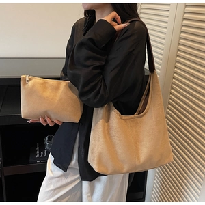 Detailed view of khaki suede tote bag and matching pouch on model for daily commute