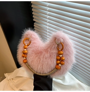 Détail du sac à main en fausse fourrure rose avec anse en perles de bois orange vif