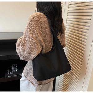 Side view of a large black vintage tote bag on model for casual commuting style