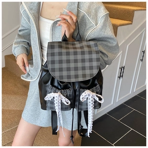 Detailed view of the plaid drawstring backpack featuring lace bow accents and soft PU leather