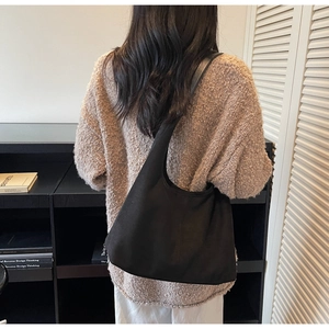 Detailed back view of a large black vintage shoulder bag styled for casual commute