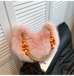 Détail du sac en fausse fourrure rose avec poignée décorative en perles de bois et corde