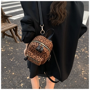 Detailed view of fashionable leopard print mini backpack with leather straps and gold hardware