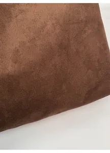 Close-up of brown suede tote bag featuring black letter print and soft texture