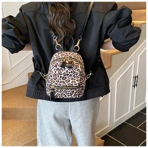 Detail of leopard print mini backpack with adjustable strap on model for size reference