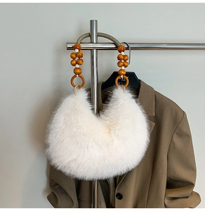 Vue détaillée d'un sac à main blanc pelucheux en fausse fourrure avec poignées perlées