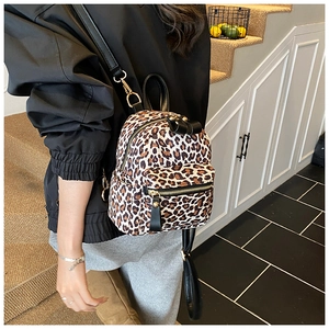 Detailed view of mini leopard print backpack with gold zippers and black leather straps