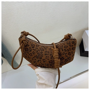 Detail of leopard print crescent bag featuring a stylish brown knotted shoulder strap