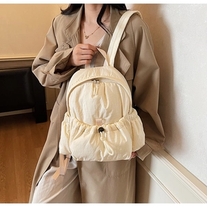 Detail of cream casual canvas backpack with drawstring pocket and crinkle nylon texture