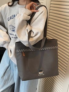 Minimalist canvas tote bag for women featuring a cartoon patch and top handle straps