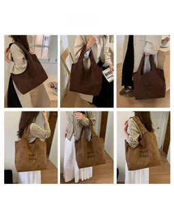 Detail showing large suede tote bags in dark coffee and light brown with letter print