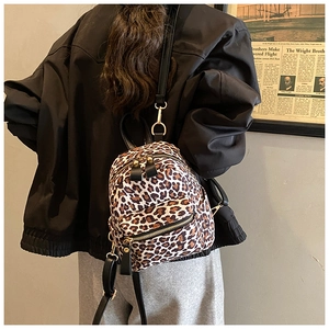 Detailed back view of a mini leopard print backpack worn by a model for size perspective