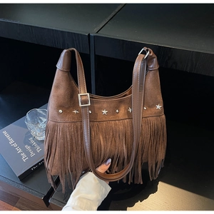 Dettaglio della borsa in pelle scamosciata marrone con frange e borchie a stella argento