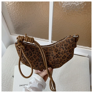 Detailed view of the leopard print crossbody bag with knotted strap and crescent shape