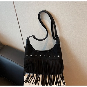 Dettaglio borsa hobo in camoscio nero con borchie a stella e frange decorative