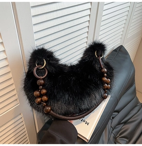 Détail du sac croissant en peluche noire avec poignée en perles de bois marron