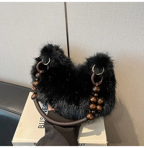 Détail du sac moumoute noir avec poignée ethnique en perles de bois et anneaux métal