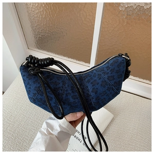 Detail of dark blue denim leopard print crescent bag with black knotted rope strap
