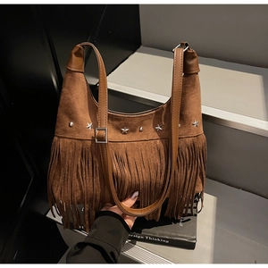 Dettaglio di una borsa hobo in camoscio marrone con borchie a stella argentate e frange lunghe