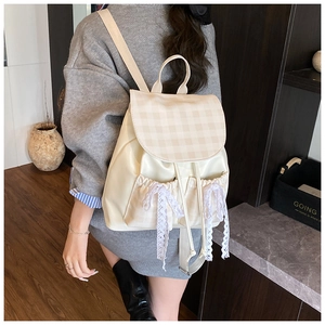 Close-up of white PU leather backpack featuring lace bow details and plaid pattern
