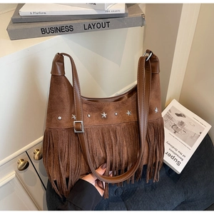 Dettaglio della borsa in pelle scamosciata marrone con frange e borchie a stella