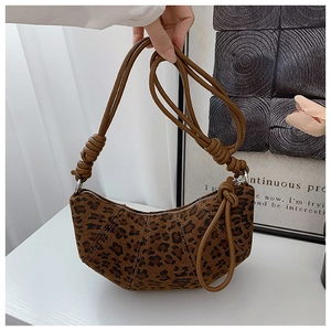 Detail of leopard print crescent bag featuring braided rope shoulder strap and knot design